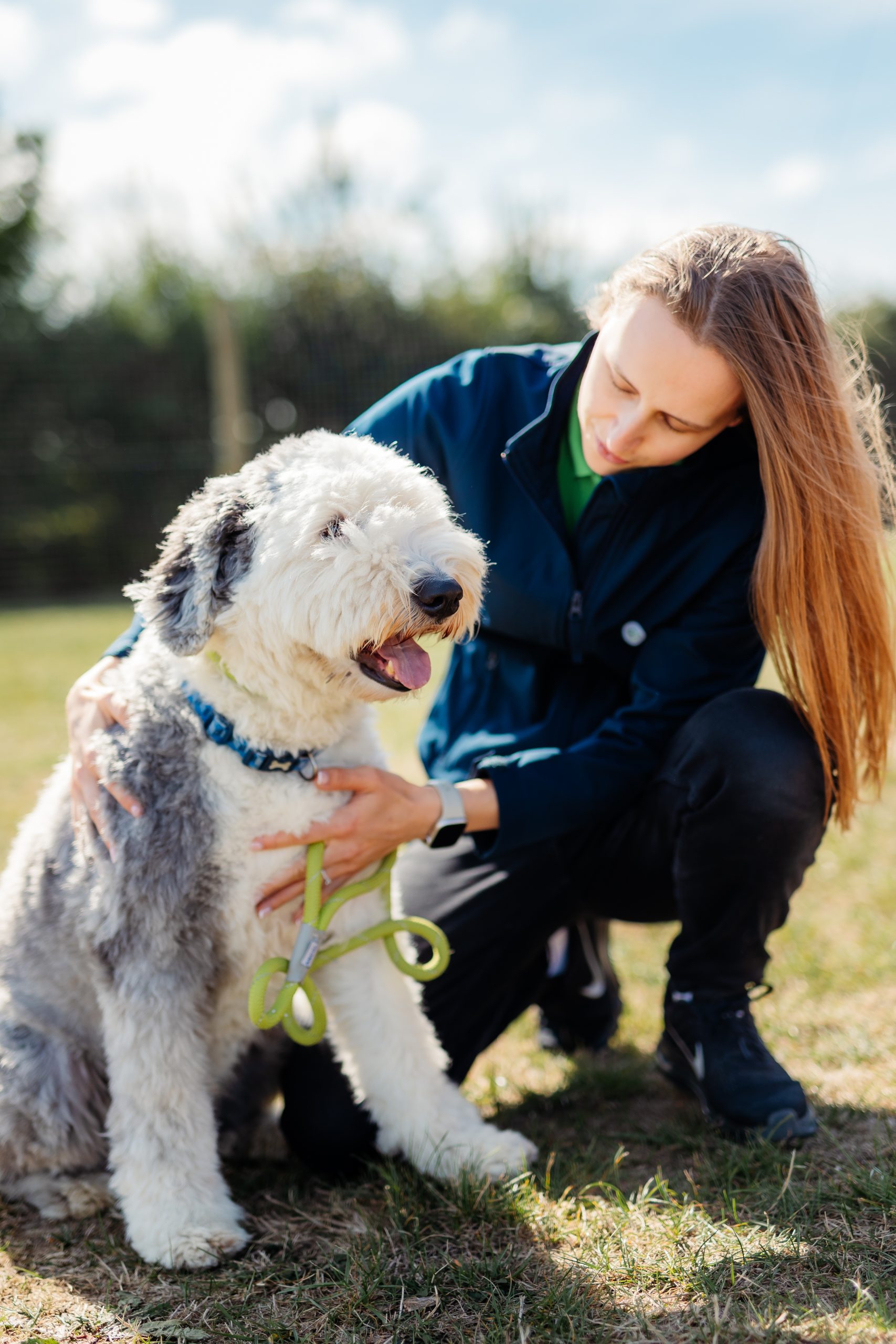 a woman kneeling down with a dog